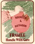 cx-15790-003.jpg - Hanging round Christmas tree ornament that reads "Sources & methods" on it's side. Caption reads, "Fragile, handle with care".

